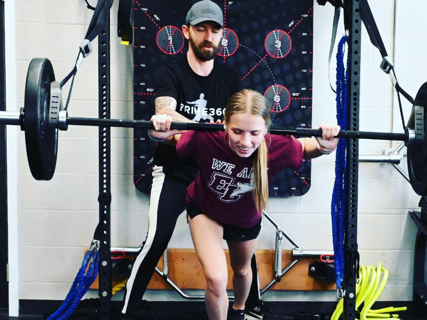 Prime360 coach spotting an athlete through a barbell split-stance drill